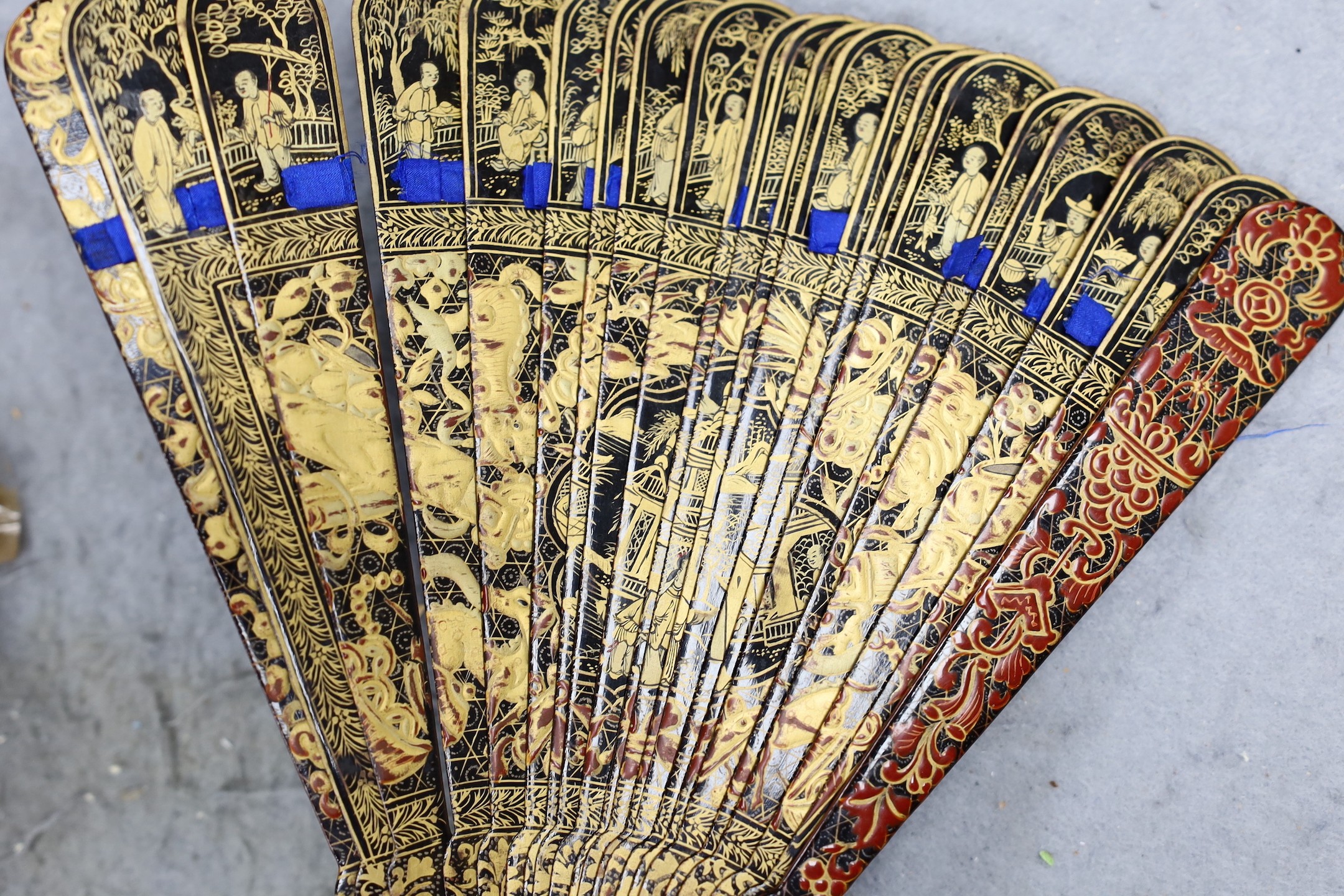 A Chinese gilt-decorated lacquer fan in a brocade covered case, 19th century